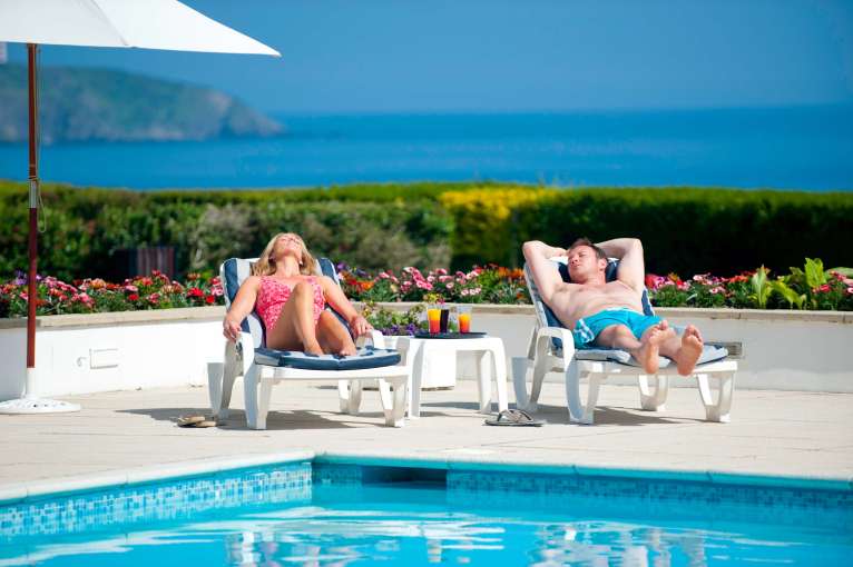 Carlyon Bay Hotel Couple on Sun Loungers by Outdoor Swimming Pool