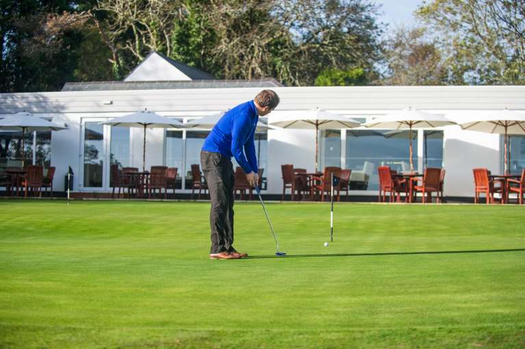 Carlyon Bay Hotel Golfer on Putting Green by Clubhouse