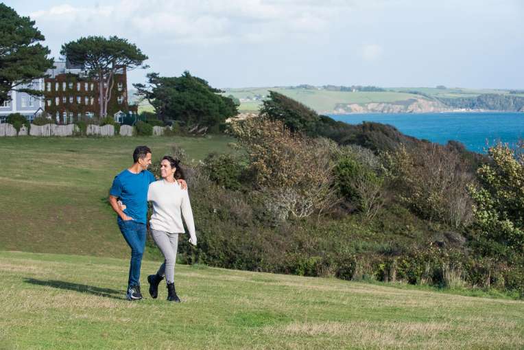 Couple walking along the coastline by the Carlyon Bay Hotel