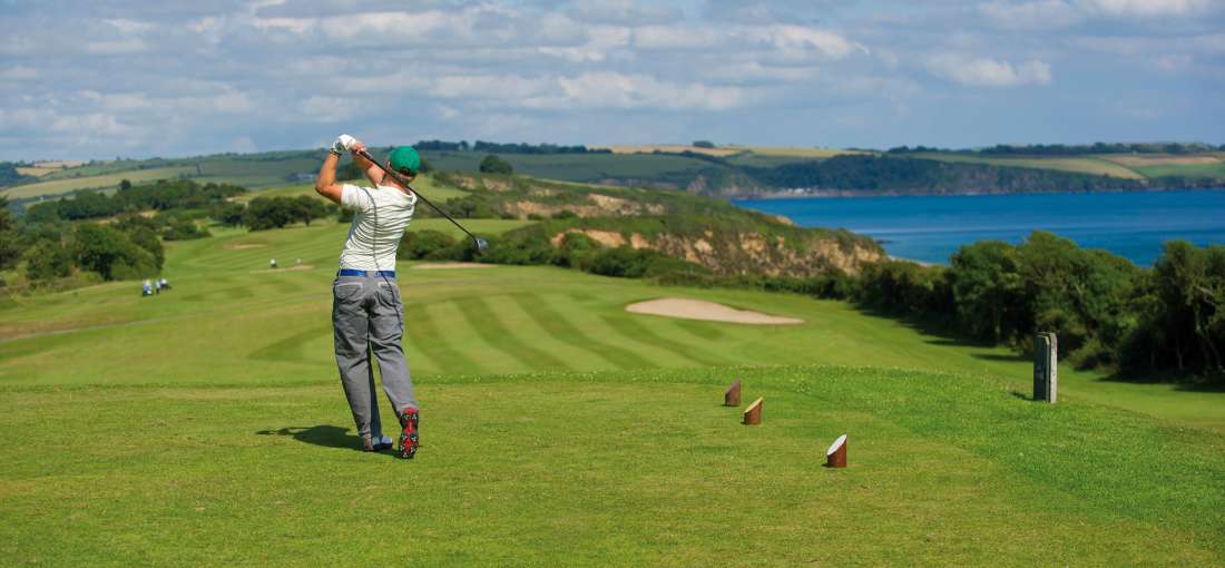 Man teen off on Carlyon Bay Golf course with sea view