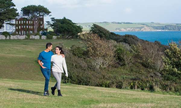 Couple walking along the coastline by the Carlyon Bay Hotel