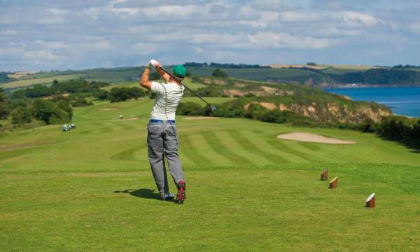 Man teen off on Carlyon Bay Golf course with sea view