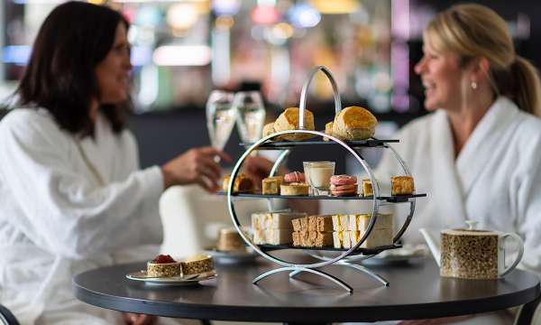 Women enjoying an Afternoon Tea with a pot of tea and glass of prosecco 