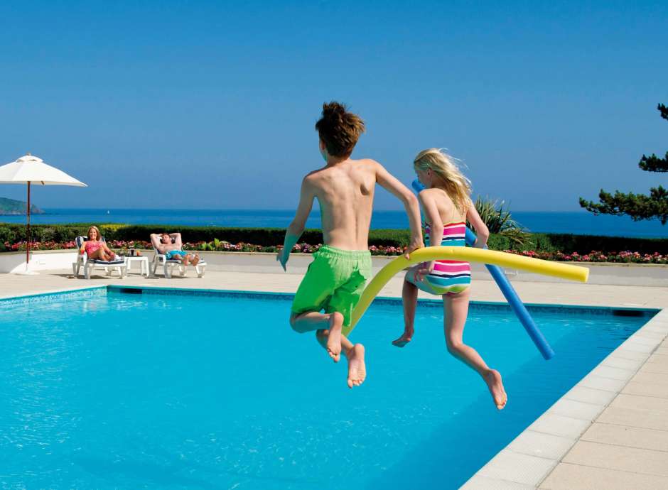 Carlyon Bay Hotel Children Jumping in Outdoor Pool and Parents on Sun Loungers