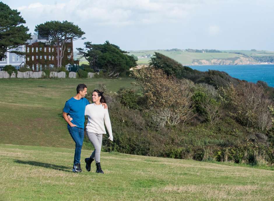 Couple walking along the coastline by the Carlyon Bay Hotel