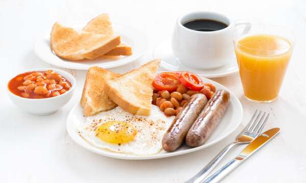 Full English breakfast with glass of fresh orange juice and cup of coffee