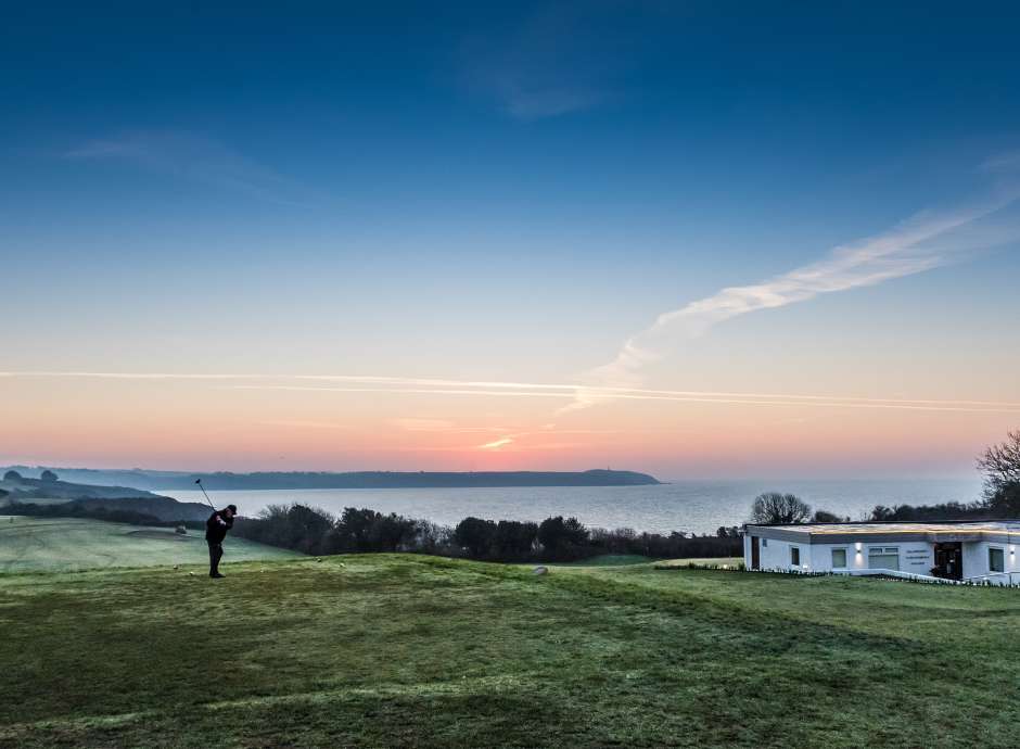 Golfer on first tee fairway and clubhouse