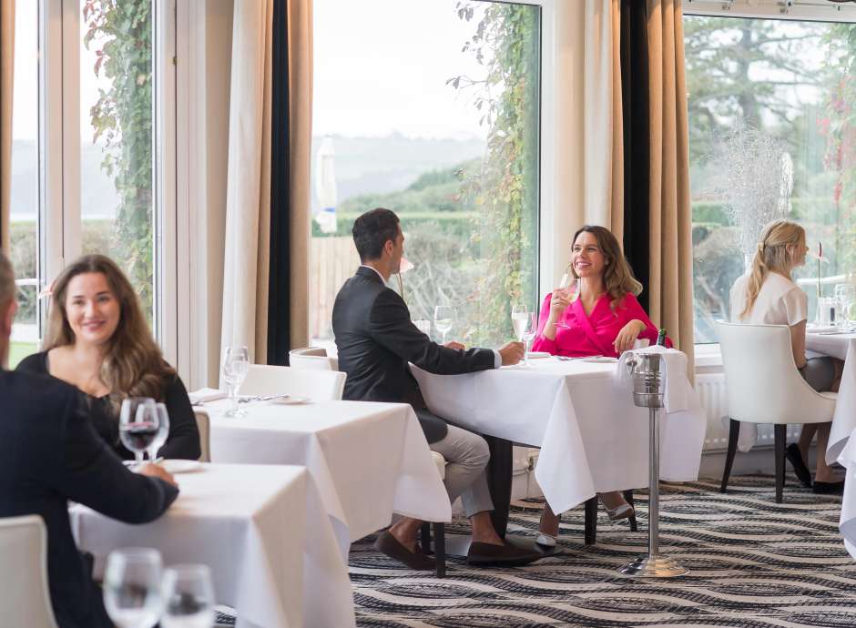 Couple sitting at a table in the Bay View Restaurant, Carlyon Bay Hotel