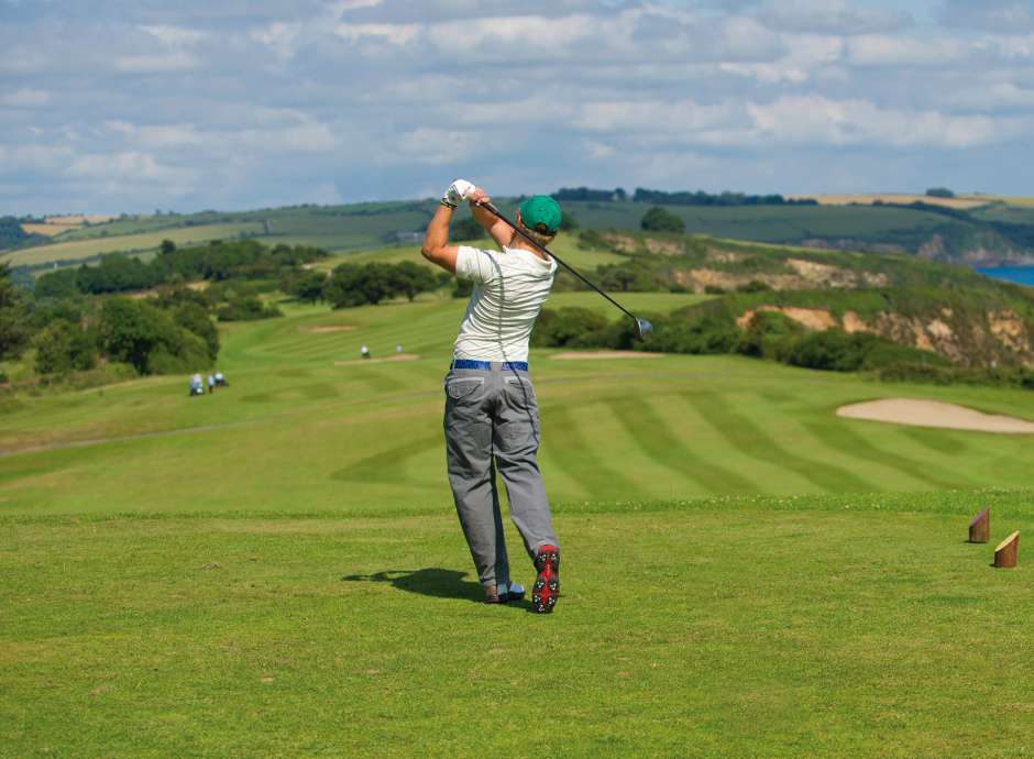 Man teen off on Carlyon Bay Golf course with sea view